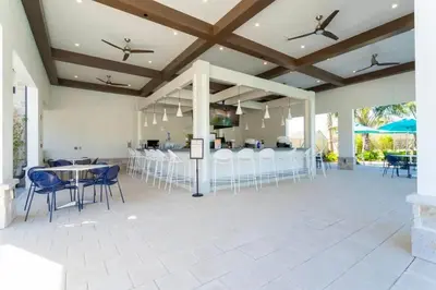a patio with tables and chairs and a bar at Marvelous 4Bd w Pool Close to Disney at Storey Lake 2629 in Kissimmee