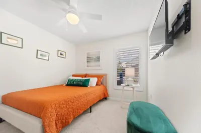 a bedroom with an orange bed and a window at Private Oasis in Kissimmee - Pool, BBQ, Free Parking in Orlando