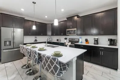 a kitchen with black cabinets and a white counter top at Storey Lake Resort, Private Pool, And Much More!! in Kissimmee