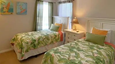 a bedroom with two beds and a dresser and a lamp at Comfort Home with BBQ, Private Pool & Hot tub in Kissimmee