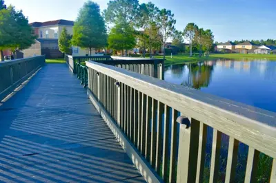 a wooden bridge over a body of water at Comfort Home with BBQ, Private Pool & Hot tub in Kissimmee