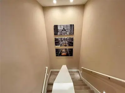 a stairway with a white bench and a picture on the wall at Family Home w BBQ, 7 Min from Disney, Accessible in Orlando