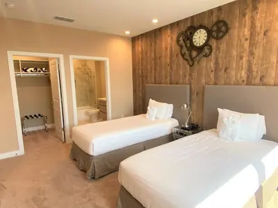 a bedroom with two beds and a clock on the wall at Family Home w BBQ, 7 Min from Disney, Accessible in Orlando