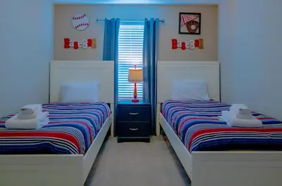 two beds in a room with blue walls at Vacation Home for 8, near Disney and Universal in Kissimmee