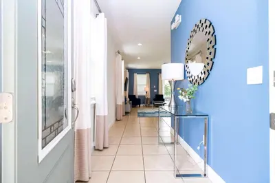 a hallway with blue walls and a mirror at Unforgettable Experience Luxury Vacation Home 7479 in Orlando
