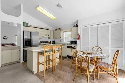 a kitchen with a table and chairs and a kitchen with white cabinets at 2974 Viscount Villa 3bed+ Pool&Spa in Kissimmee