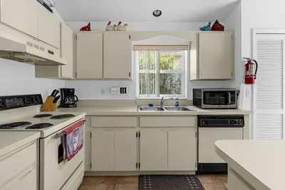a white kitchen with white cabinets and a sink at 2974 Viscount Villa 3bed+ Pool&Spa in Kissimmee