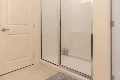 a shower with a glass door in a bathroom at Summer Fun - Waterfront 8BR Home with Private Pool! in Kissimmee