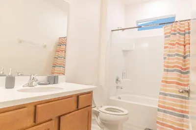a bathroom with a sink and a toilet and a shower at Summer Fun - Waterfront 8BR Home with Private Pool! in Kissimmee