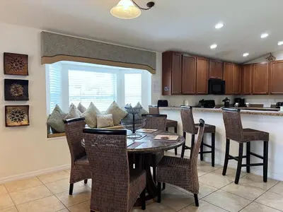 a kitchen and dining room with a table and chairs at Cozy 4 Bed 3 Bath Pool Hm with Game Room-4450NP in Kissimmee
