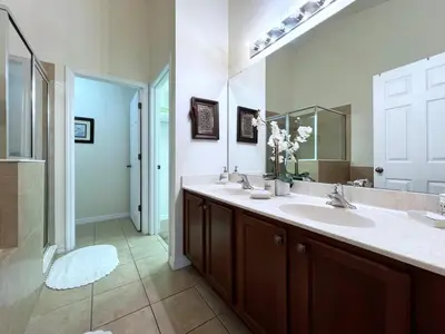 a bathroom with two sinks and a large mirror at Cozy 4 Bed 3 Bath Pool Hm with Game Room-4450NP in Kissimmee