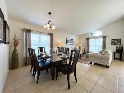 a dining room with a table and chairs and a couch at Cozy 4 Bed 3 Bath Pool Hm with Game Room-4450NP in Kissimmee