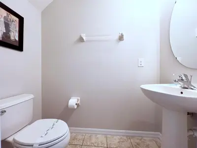 a white bathroom with a toilet and a sink at Beautiful 6Bd Pool Hm Veranda Palms-4464NP in Kissimmee