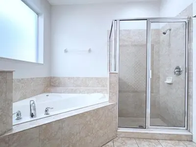 a bathroom with a tub and a glass shower at Beautiful 6Bd Pool Hm Veranda Palms-4464NP in Kissimmee