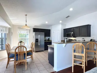 a kitchen and dining room with a table and chairs at Lovely Lakeside 4-Bed Pool Home at Villa Sol-3125 in Kissimmee