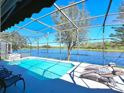 a swimming pool with a view of the water at Lovely Lakeside 4-Bed Pool Home at Villa Sol-3125 in Kissimmee