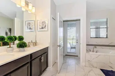 a white bathroom with a tub and a sink and a bath tub at 33 Disney Villa GameRoom Movie Theater Pool in Kissimmee