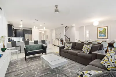 a living room with a couch and a living room and a kitchen at 33 Disney Villa GameRoom Movie Theater Pool in Kissimmee