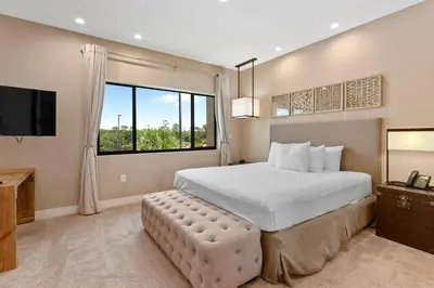 a bedroom with a large bed and a large window at 7583 Magic Village jacuzzi 3 suites near 192 and Disney in Orlando