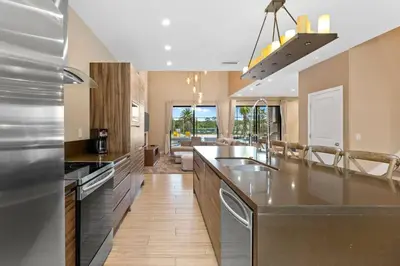 a kitchen with stainless steel appliances and a large island at 7583 Magic Village jacuzzi 3 suites near 192 and Disney in Orlando