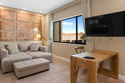 a living room with a couch and a flat screen tv at 7583 Magic Village jacuzzi 3 suites near 192 and Disney in Orlando