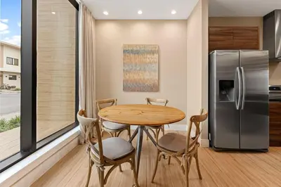 a kitchen with a table and a refrigerator at 7545 Magic Village 4 suites 8 guests 8 min Disney in Orlando