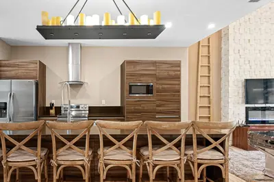 a kitchen with a table with chairs and a refrigerator at 7545 Magic Village 4 suites 8 guests 8 min Disney in Orlando