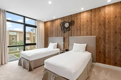 two beds in a room with wooden walls at 3081 Magic Village 4suites Jacuzzi Near 192 8 min Disney in Orlando