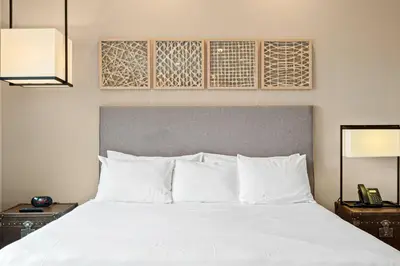 a bedroom with a white bed with two night stands at 3081 Magic Village 4suites Jacuzzi Near 192 8 min Disney in Orlando