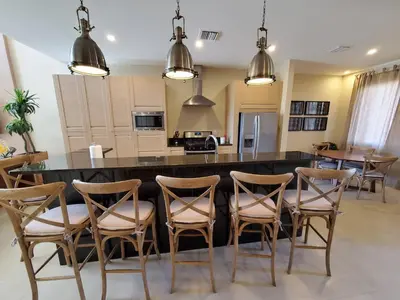 a kitchen with a large island with chairs around it at 7659 Magic Village Excellent 4 suites 6 min Disney in Orlando