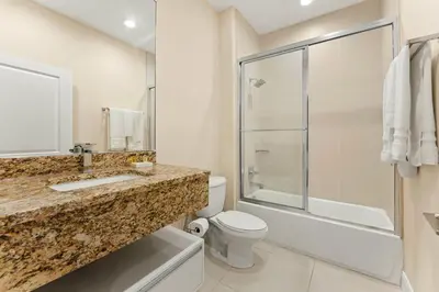 a bathroom with a sink and a toilet and a shower at 7659 Magic Village Excellent 4 suites 6 min Disney in Orlando