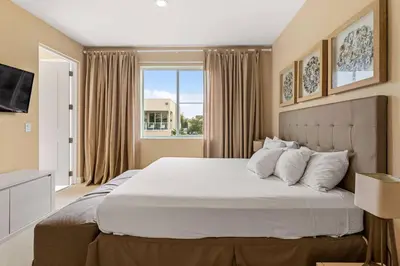 a bedroom with a large white bed with a window at 7648 Magic Village lovely 4suites 8guests 8 min Disney in Orlando