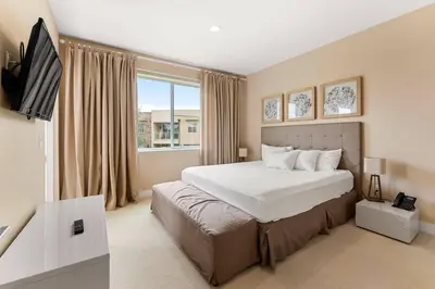 a bedroom with a large bed and a television at 7648 Magic Village lovely 4suites 8guests 8 min Disney in Orlando