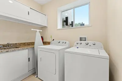 a white laundry room with two washes and a window at 7648 Magic Village lovely 4suites 8guests 8 min Disney in Orlando