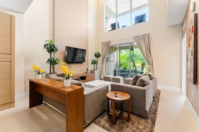 a living room with a couch and a tv at 7648 Magic Village lovely 4suites 8guests 8 min Disney in Orlando