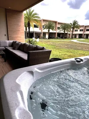 a jacuzzi tub in a yard with a couch at 7458 Magic Village 3suites 8guests jacuzzi 8 min Disney in Orlando