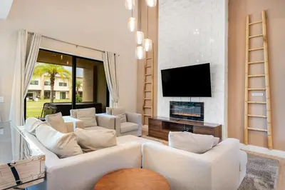 a living room with white furniture and a flat screen tv at 7458 Magic Village 3suites 8guests jacuzzi 8 min Disney in Orlando