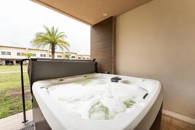 a bath tub in a room with a window at 7458 Magic Village 3suites 8guests jacuzzi 8 min Disney in Orlando