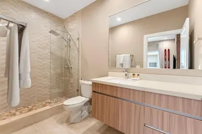 a bathroom with a toilet and a sink and a shower at 7458 Magic Village 3suites 8guests jacuzzi 8 min Disney in Orlando