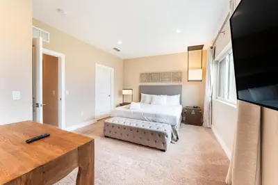 a bedroom with a bed and a flat screen tv at 7458 Magic Village 3suites 8guests jacuzzi 8 min Disney in Orlando