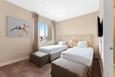 a hotel room with two beds and a bike on the wall at 3212 Magic Village 8 guests lakefront 8 min Disney in Orlando