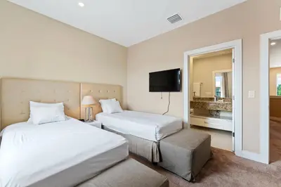 a hotel room with two beds and a flat screen tv at 3212 Magic Village 8 guests lakefront 8 min Disney in Orlando