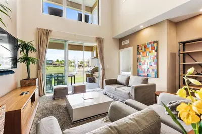 a living room with a couch and a tv at 3212 Magic Village 8 guests lakefront 8 min Disney in Orlando