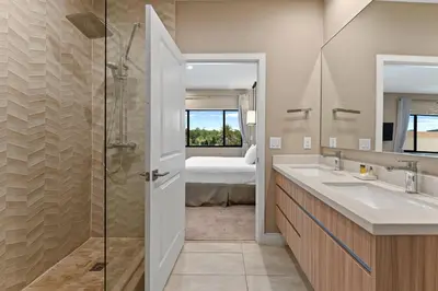 a bathroom with a shower and a sink and a bed at 7564 Magic Village 3 suites jacuzzi BBQ 8 min Disney in Orlando