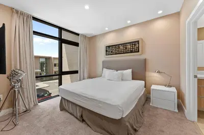 a bedroom with a bed and a large window at 7564 Magic Village 3 suites jacuzzi BBQ 8 min Disney in Orlando