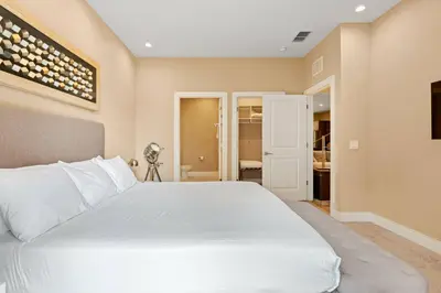 a bedroom with a white bed and a bathroom at 3045 Magic Village8 guests 4 suites BBQ 8 min Disney in Orlando