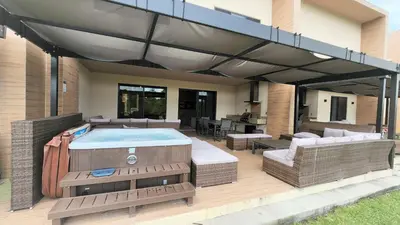 an outdoor deck with a hot tub and a patio at 3053 Magic Village 3 suites jacuzzi BBQ 6min Disney in Orlando