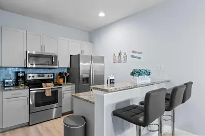 a kitchen with white cabinets and stainless steel appliances at 3212 WL 8 guests corner 192 near from Disney in Kissimmee
