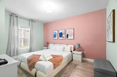 a bedroom with a large bed with pink walls at 3212 WL 8 guests corner 192 near from Disney in Kissimmee