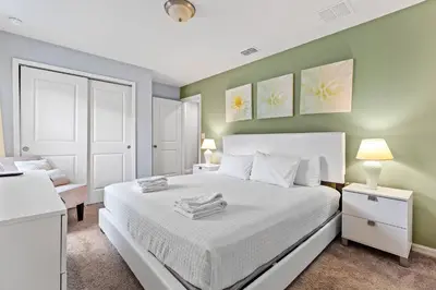 a bedroom with a white bed and a chair at 5129 Tasty renovated 8 guests BBQ near Disney in Kissimmee